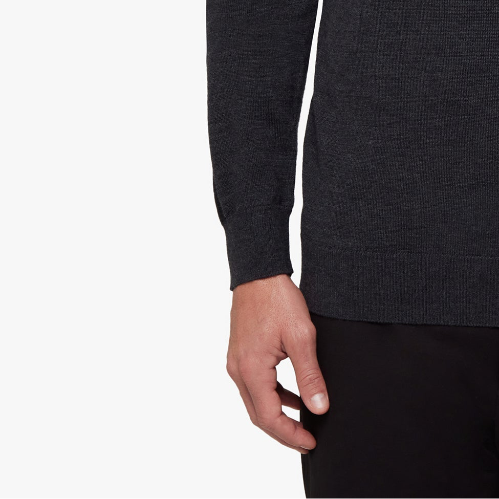 Dark gray long-sleeve shirt worn by a person on a white background