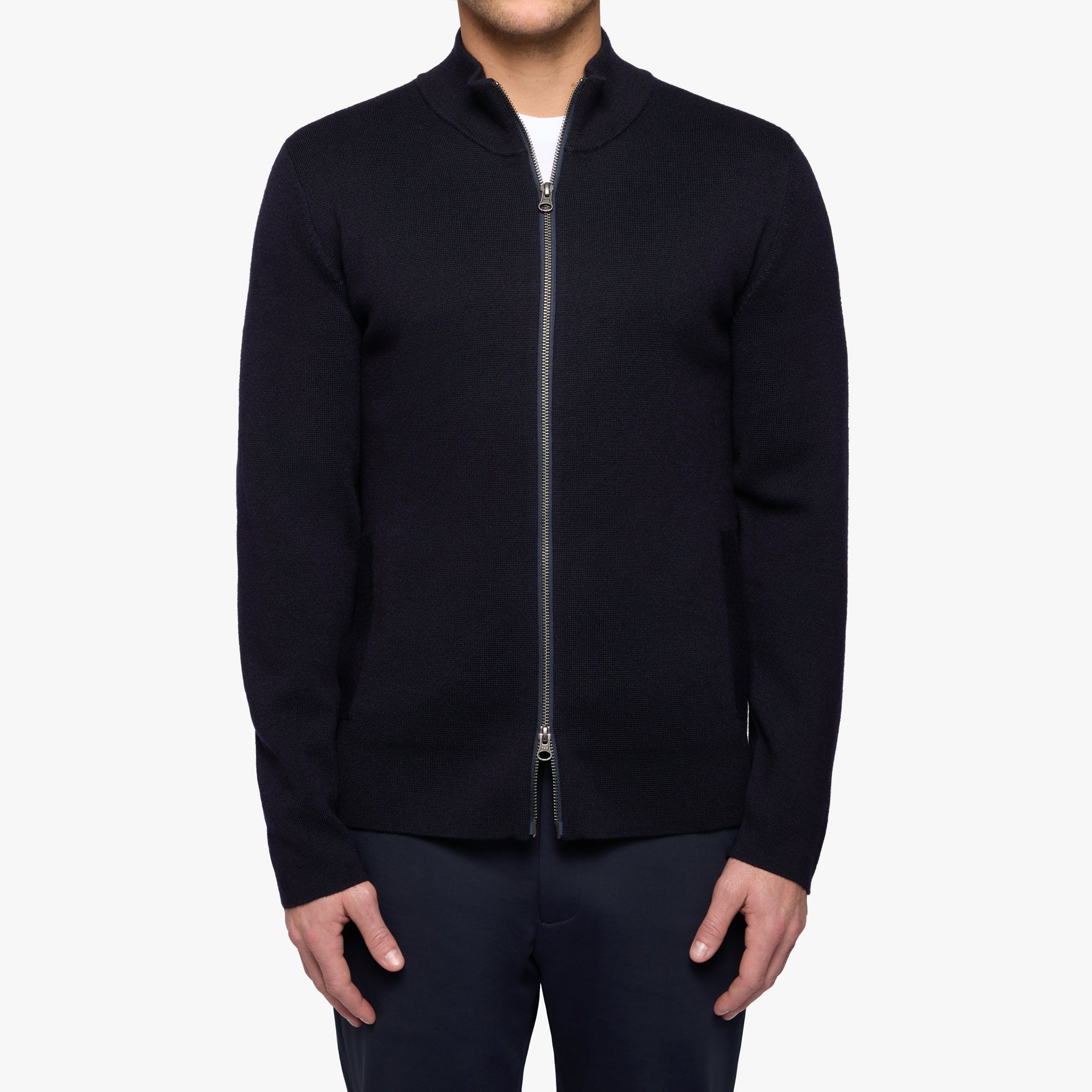 Person wearing a black zip-up jacket on a white background