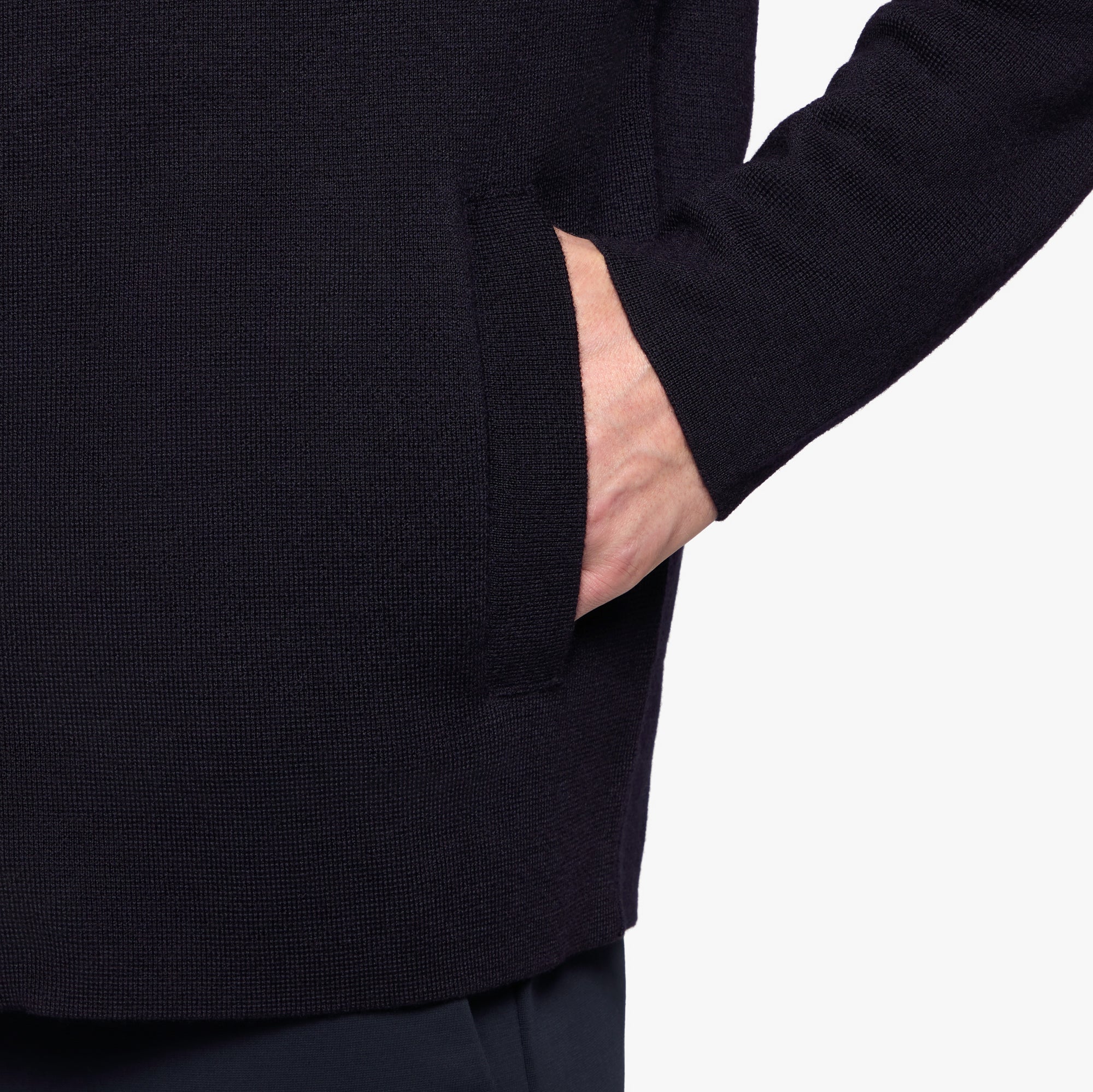 Person wearing a dark blue sweater with a white background